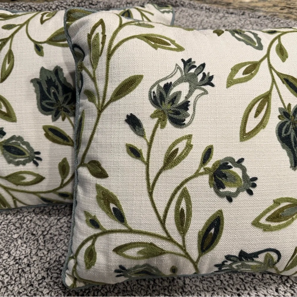 Two decorative pillows with green/blue tulip design.